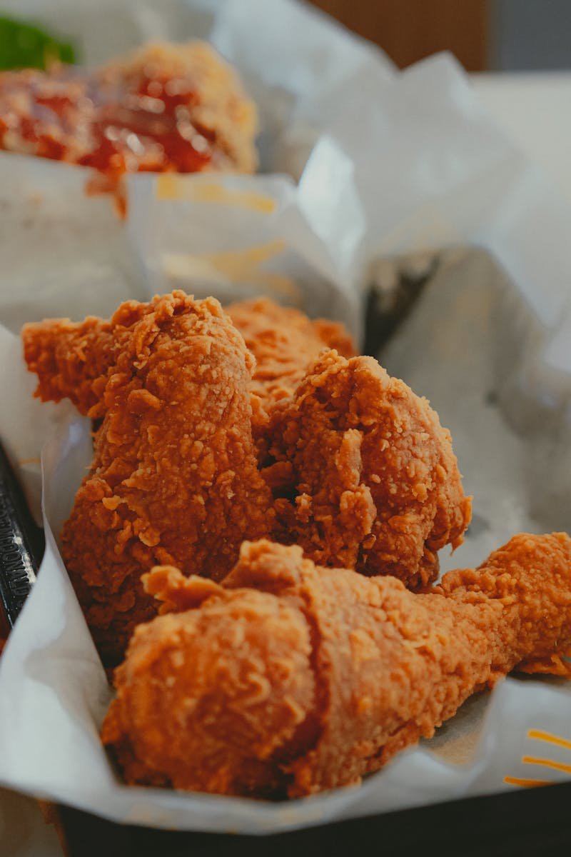 Close-up of crispy fried chicken and fries in a fast food restaurant.